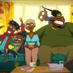 In this still from the 'Good Times' animated series, a Black family of five sits on a teal couch in the living room and poses for a family photo. The mom (short blond hair) smiles nicely in the center of the photo while her adolescent son and daughter playfully jostle one another to her right. Her husband takes up all of the other half of the couch as their baby pulls his hair and cheek.