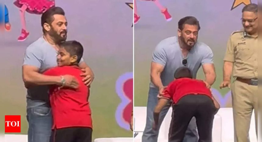 Salman Khan gives a hug to a young fan on stage as he touches his feet at Ganesh Chaturthi event